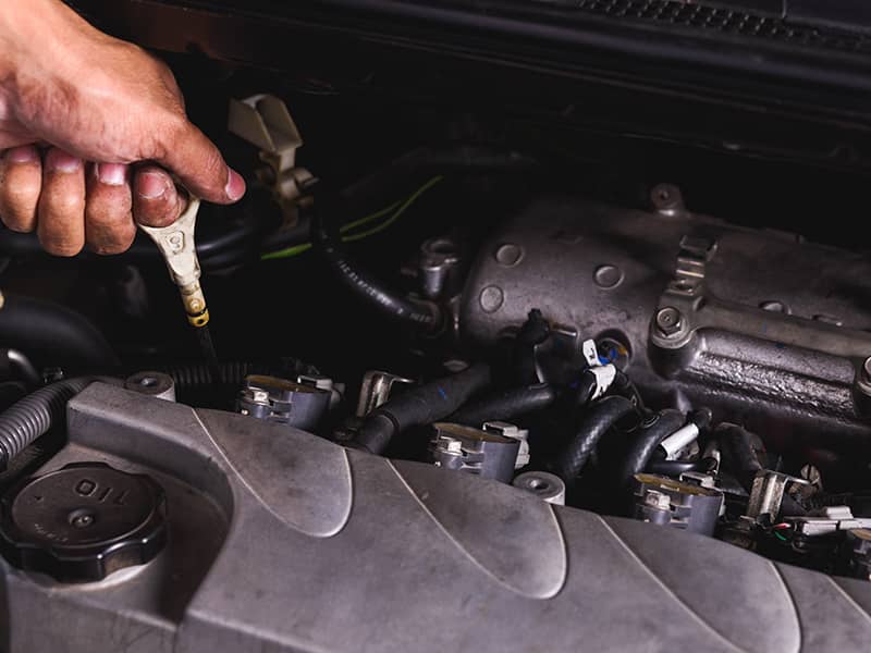 Hand of Mechanic technician service check level motor oil engine in garage