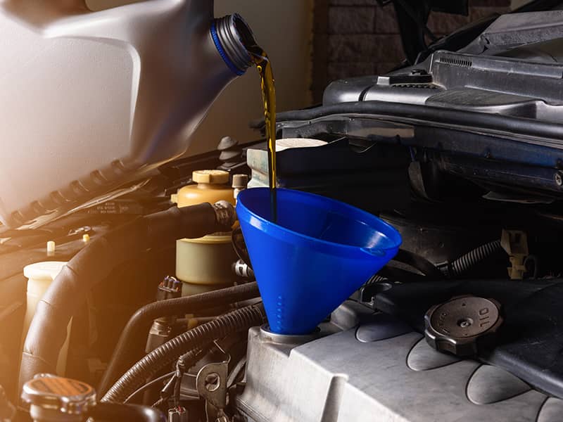 Hand mechanic in service to repair a car, pouring change lubricant oil at maintenance repair service station, Energy fuel maintenance automotive concept